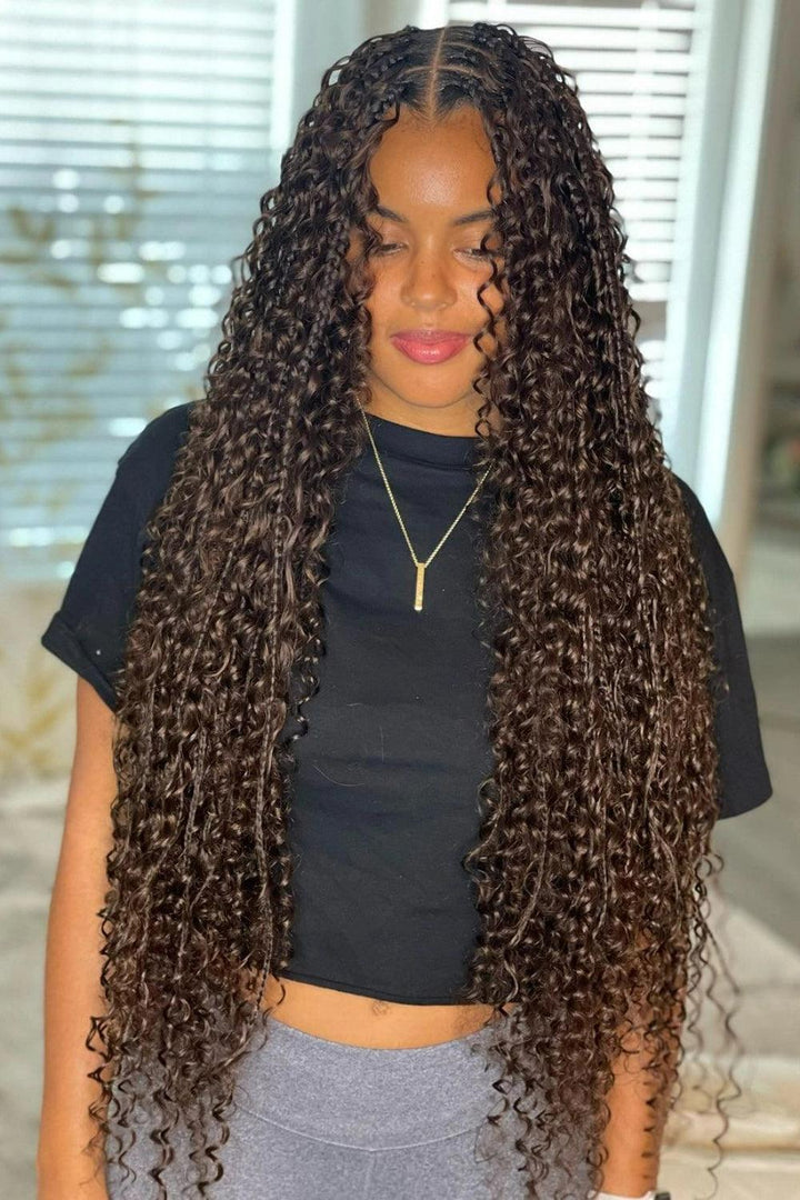Front view of a smiling Black woman displaying color 4 boho knotless braids